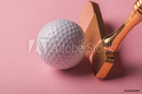 Picture of Head of luxury golden golf club near golf ball on pink background